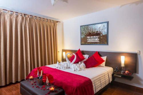1 dormitorio con 1 cama grande con almohadas rojas en Casablanca Hotel, RestoBar, Catering, Eventos & Turismo en Garzón, en Garzón