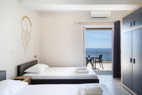 a bedroom with two beds and a view of the ocean at Nirvana Homes in Vlachata
