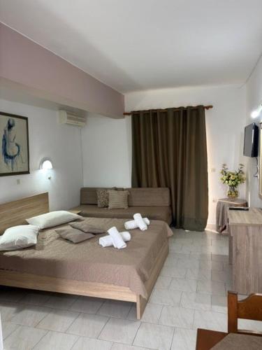 ein Schlafzimmer mit einem großen Bett, auf dem Handtücher liegen in der Unterkunft STUDIO ZOE in Marmari
