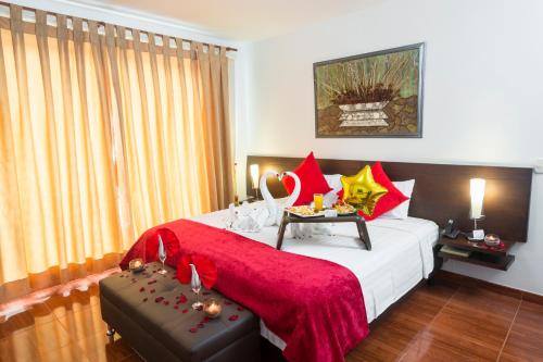 a bedroom with a large bed with red and yellow pillows at Casablanca Hotel, RestoBar, Catering, Eventos & Turismo en Garzón in Garzón