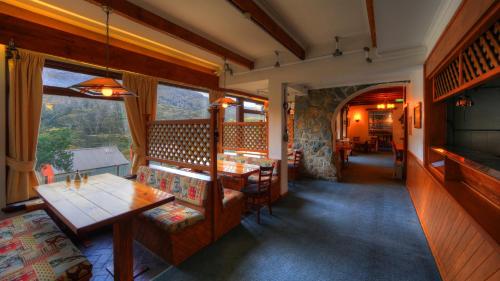 a restaurant with tables and chairs and a large window at Candlelight Lodge in Thredbo