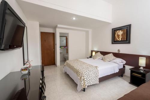 a bedroom with a bed and a flat screen tv at Casablanca Hotel, RestoBar, Catering, Eventos & Turismo en Garzón in Garzón
