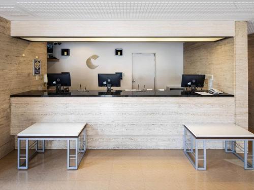 a waiting room with two tables and a counter at Comfort Hotel Sakai in Sakai