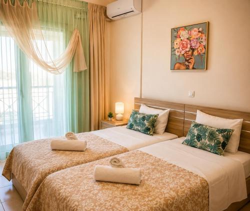 two beds in a hotel room with two beds at Stasa Luxury Apartments in Keramoti