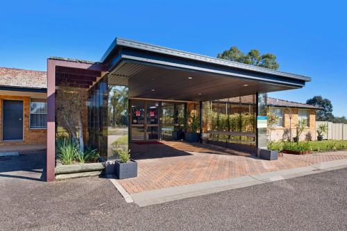 a store front with glass doors and potted plants at Econo Lodge Savannah Park Tamworth in Tamworth