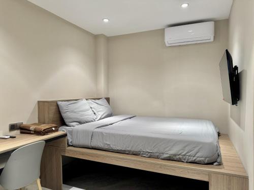 a bedroom with a bed and a desk with a computer at WH302 Residence by WH in Phnom Penh
