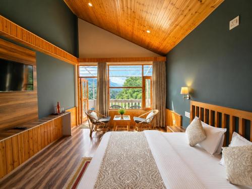 a bedroom with a large bed and a table at Doris Mountain Cabins Tirthan Jibhi in Banjār