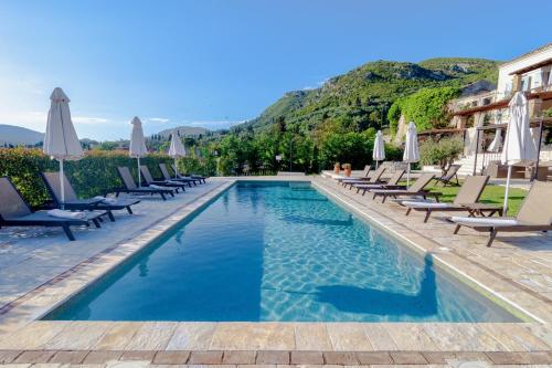 a pool at a hotel with chairs and umbrellas at Marcora Historic Mansion in Strongylí