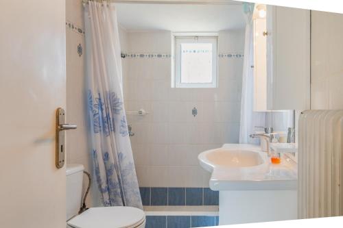 a bathroom with a toilet and a sink at Kyma Arch House in Porto Heli