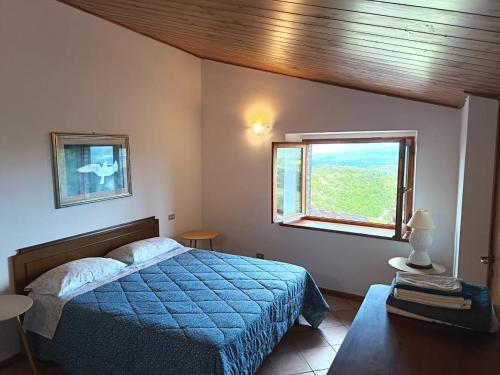 a bedroom with a blue bed and a window at Chalet Amandola in Moglietta