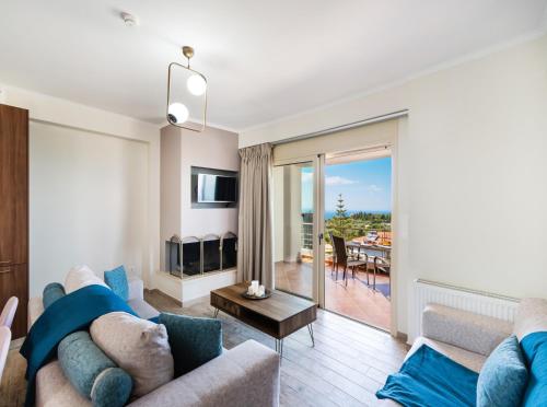 a living room with a couch and a tv and a table at Cataleya - Sea & Sunset View Apartment in Tsoukalades