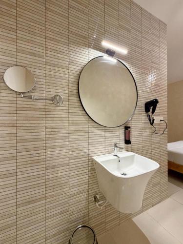 a bathroom with a sink and two mirrors on the wall at NestSort Hotel in Mysore