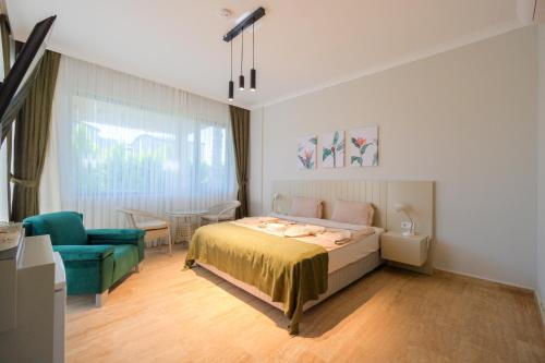 a bedroom with a bed and a blue chair at EDEN NEST EXCLUSIVE HOTEL in Belek