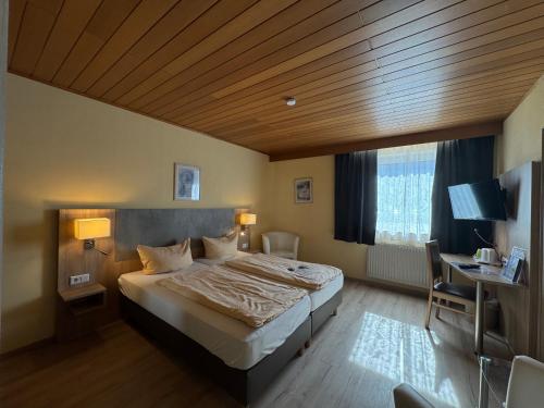 a bedroom with a large bed and a wooden ceiling at Hotel am Rosenbad in Fulda