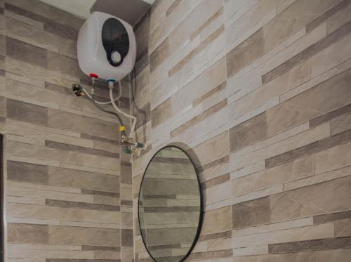 a bathroom with a mirror and a hair dryer on the wall at Maxbliss Optimum Royal Hotel in Benin City