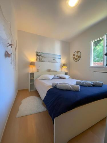 a bedroom with a large bed with blue sheets and pillows at Le COCON DU BASSIN in Arès