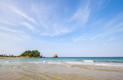 a beach with a blue sky and the ocean at Chorok Pension in Boryeong