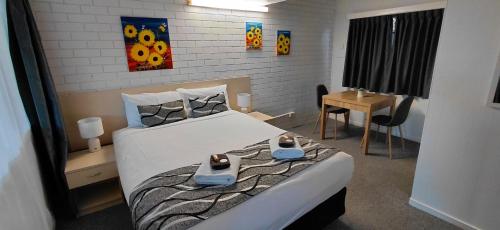 a bedroom with a bed with shoes on it at Kaputar Motel in Narrabri
