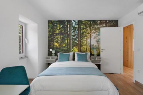 a bedroom with a bed with a painting on the wall at Casa Aurora in Campo do Gerês