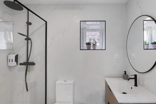 a white bathroom with a sink and a mirror at Casa Aurora in Campo do Gerês