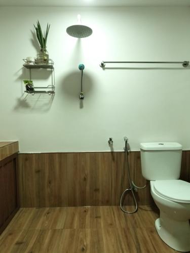 a bathroom with a white toilet and a lamp at DGH Jasaan in Jasaan