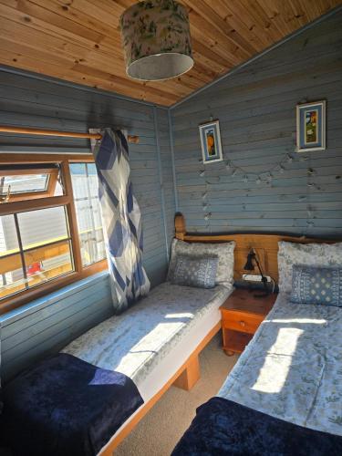 a bedroom with two beds in a log cabin at Unique Caravan with Outdoor Space Lodge in Ballantrae