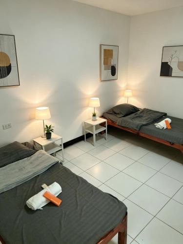 a room with two beds and two tables with lamps at DGH Jasaan in Jasaan