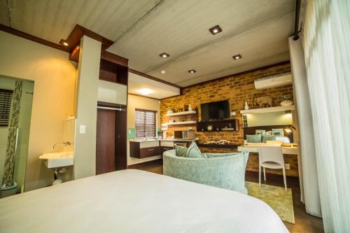 a room with a bed and a kitchen and a living room at Grey Manor Guesthouse in Potchefstroom