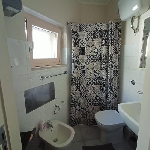 a bathroom with a toilet and a shower curtain at Casa Canale in Gesualdo