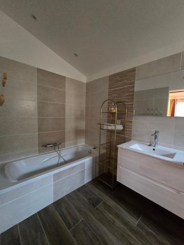 a bathroom with a tub and a sink at Superbe villa avec piscine in Bras