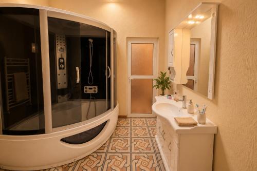 a bathroom with a tub and a sink and a shower at Retro Palace Residence Tashkent in Toshkent-Passajir Bekati