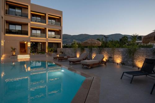 a house with a swimming pool in front of a building at Stella Maria Hotel & Suites in Malia