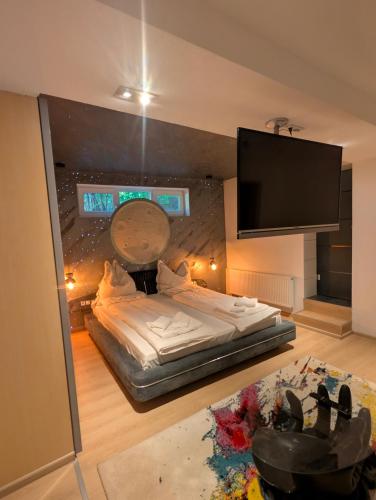 a bedroom with a bed and a flat screen tv at Casa din padure in Orşova