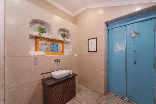 a bathroom with a sink and a blue door at La casa Verde 4BHK with Private Pool, Baga in Baga