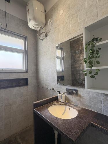 a bathroom with a sink and a mirror at Red Brick House in Panchkula