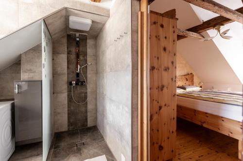 a bathroom with a shower and a bed at DACHJUWEL Luxus - Apartment Penthouse Ferienwohnung in Leibnitz