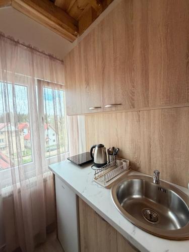 a kitchen counter with a sink and a window at Lux Studio Apartments in Žabljak