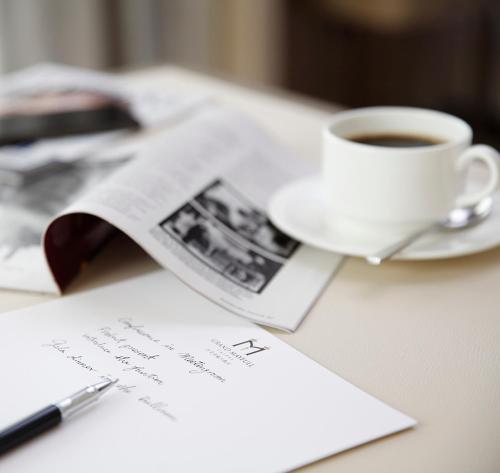 a cup of coffee and a newspaper on a table at Grand Mayfull Taipei in Taipei