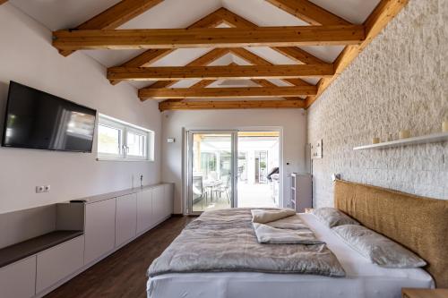 a bedroom with a bed and a flat screen tv at DACHJUWEL Luxus - Apartment Penthouse Ferienwohnung in Leibnitz