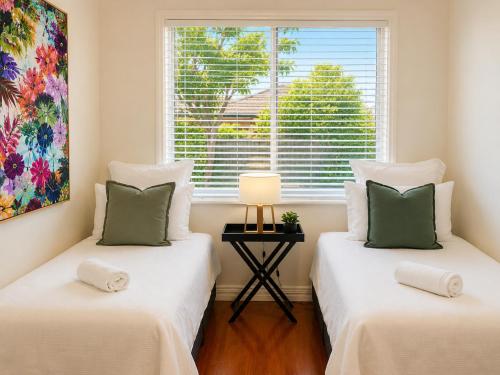 two beds in a room with a window at Light-Filled Modern Home 3BR Pet-Friendly 5km-CBD in Perth