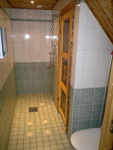 a bathroom with a shower with a toilet and a sink at Rivitahko 5 in Tahkovuori