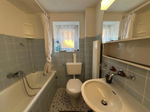 a bathroom with a sink and a toilet and a bath tub at Chalet Montes in Lauterbrunnen