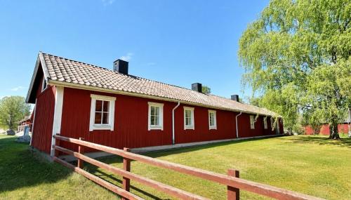 a red house with a wooden fence in front of it at Valla Vandrarhem in Linköping