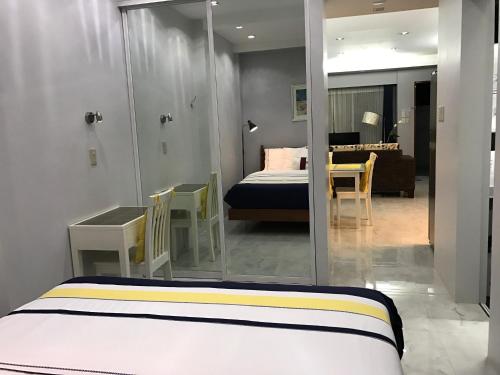 a bedroom with a bed and a room with a mirror at Anavada Suites - Davao City in Davao City