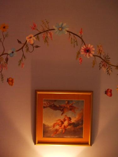 a painting of a branch with flowers on a wall at Hotel Posada del Angel in Cuenca