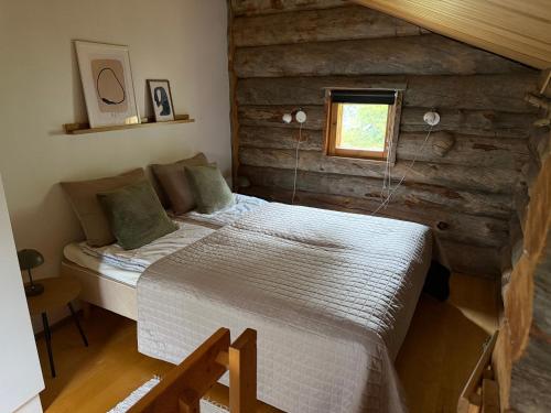 a bedroom with a bed in a log cabin at Voimakelo - renovated - near ski bus in Kuusamo