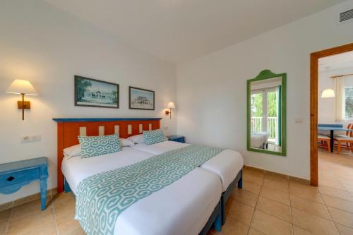 a bedroom with a large bed with blue and white sheets at Comitas Isla del Aire in Punta Prima