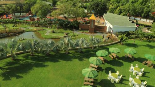 an overhead view of a park with tables and green umbrellas at Gulmohar Greens Golf & Country Club in Sānand