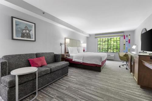 a hotel room with a couch and a bed at Hampton Inn Salem in Salem