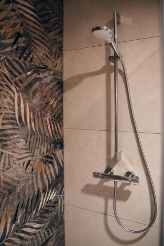 a shower with a shower head in a bathroom at Hotel Wirt Weissau in Oberweißau